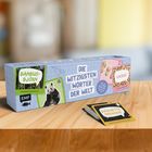 Texte: "DIE WITZIGSTEN WÖRTER DER WELT", "BAMBUSBJÖRN", "KIKIRIKI", "BAGUETTE MAGIQUE". Eine Box mit Karten auf Holz.