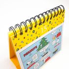 Text "15" und "PEANUTS" sichtbar. Eine Tischkalenderseite mit Comic, gelbem Hintergrund und Weihnachtsmotiven.