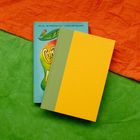 Ein Buch mit dem Text: "ONE GIRL. ONE ANONYMOUS POST. A SCHOOL-WIDE MOVEMENT." auf buntem Papierhintergrund.