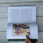 Text: "Christmas morning". Illustration: Ein Weihnachtsmann mit Spielzeugen und einem Hasen. Eine Hand hält das Buch.