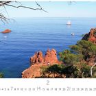 "Nordküste" steht links. Kalenderblatt 2, umgeben von roten Felsen, Bäumen und blauem Meer mit Segelbooten.