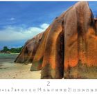 La Dique, Seychellen. Unten Kalenderzahlen, Monatszahl: 2. Tropischer Strand mit markanten, rötlichen Felsen und blauem Himmel.