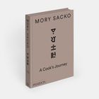 "Mory Sacko: A Cook’s Journey" steht auf einem beigen Buchcover. Darunter ein stilisiertes schwarzes Logo.