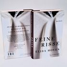 Ein Buch mit dem Titel "FEINE RISSE" von Elisa Hoven, darunter "Roman". Text: "JEDES VERBRECHEN BEGINNT MIT EINEM GEHEIMNIS".