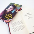 Buchcover und Innenseite eines Buches mit "Gabriele Reuter, Das Tränenhaus, Roman" sowie einer Illustration einer Frau.