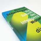 Buchcover mit Text: "Manuel Scheidegger. Die Zukunft der Intelligenz. Warum wir dümmer künftiger sind." Farben: Grün, Blau, Gelb.
