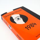 „1984. George Orwell. A Novel. Reclam Originals.“ Auf rotem Buchcover mit stilisiertem Auge-Design.