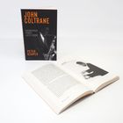 "JOHN COLTRANE, BIOGRAPHIE EINER JAZZ-IKONE, PETER KEMPER." Geschlossenes Buch steht, aufgeschlagenes Buch liegt davor.