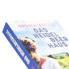 „Ursula Kissel, Das Heidelbeerhaus, Roman“. Cover mit Landschaft und Frau von hinten.