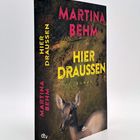 „Martina Behm“, „Hier Draußen“, „Roman“. Illustration eines Rehs im Wald. Logo „dtv“ am Buchrücken.