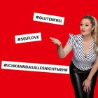 #GLUTENFREI, #SELFLOVE, #ICHKANNDASALLESNICHTMEHR. Frau mit gestreiftem Oberteil und ausgestrecktem Arm vor rotem Hintergrund.