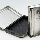 Text: "Sebastian Fitzek, Der Nachtzug, Psycho-Thriller, Droemer." 

Ein Buch mit metallischem Einband neben einer leeren Box.