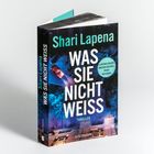 Auf dem Buchcover steht "Shari Lapena, WAS SIE NICHT WEISS, THRILLER". Ein Auto fährt auf einer Straße durch einen Wald.