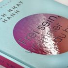 Ein Buch mit dem Titel "Frei sein, wo immer du bist" von Thich Nhat Hanh. Türkises Cover mit lila Kreis.