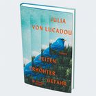 "Julia von Lucadou, Zeiten erhöhter Gefahr, Roman" in orange Schrift. Ein blauer Vogel über einem Wald.