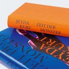 „Şeyda Kurt: Zeit der Monster“ in schwarzer Schrift auf orangenem Buchrücken. Darunter ein blaues Buchcover.