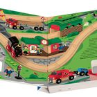 Illustration eines Bahnhofs mit buntem Zug, Figuren und Fahrzeugen, darunter ein rotes Auto, Menschen und Tiere im Park.