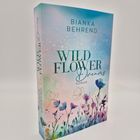 „Wild Flower Dreams: Roman“ von Bianka Behrend. Cover mit Aquarell-Wildblumen vor pastellfarbenem Hintergrund.