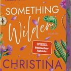 "Sie suchen einen Schatz und landen direkt im Gefühlschaos. Something Wilder. Roman. Spiegel Bestseller-Autorin. Christina Lauren." Ein orangefarbener Hintergrund mit lila Blüten, einem grünen Chamäleon und Kakteen.