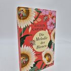 „EILEEN GARVIN, Die Melodie der Bienen, Roman“ auf rotem Buchcover mit Sonnenblumen und Bienen.