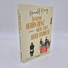 Auf einem beigen Buchcover steht in großer Schrift: "Er kenne Herrn Benz nicht, sagt Herr Daimler." Darunter Bild von Männern in alten Autos.