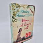 "Gaby Hauptmann: Wenn ich tanzen will. Roman. SPIEGEL Bestseller Autor. Frau sitzt nachdenklich auf einem Steg, umgeben von Bäumen."