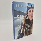 "STURZ IN DIE TIEFE", Gela Allmann. Frau mit Mütze und Skibrille, Berg im Hintergrund.