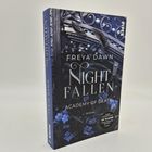 Ein Buch mit Titel "Nightfallen: Academy of Death" von Freya Dawn, Cover mit Federn und blauen Blumen.