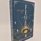 "Heller als Feuer", Roman von Alice Doubier. Ein Cover mit Sonnenaufgang, Bergen und Figuren.