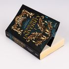 Text: "Lauren Harmening Montcrest University." Ein Buch mit reich verziertem goldenen Design auf dem Cover.