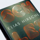Text: "ELIAS HIRSCHL". Stilvolle, geschwungene Buchstaben in orangefarbenen Linien auf dunklem Hintergrund.