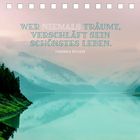 Zitat: „Wer niemals träumt, verschläft sein schönstes Leben.“ – Friedrich Rückert. Ruhiger See mit Bergen im Hintergrund.