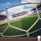 Kalenderseite: Februar 2027. Blick durch ein Fußballtor auf ein leeres Stadion bei klarem Himmel und grüner Rasenfläche.