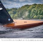 Der Text zeigt: "B-BX 968" und darunter eine Monatsübersicht. Ein elegantes, dunkles Segelboot gleitet durch welliges Wasser.