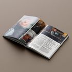 Eine offene Zeitschrift zeigt links ein Porträt und eine Szene vor einer Backsteinwand, rechts eine Frau am Computer.