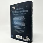 Rückseite eines Buches mit dem Titel "Schatten über der Wyndhouse Academy". Dunkles Design mit weißen Motiven.