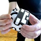 Ein schwarz-weißer Würfel mit Buchstaben wird von zwei Händen gehalten, die Buchstaben sind teilweise erkennbar.