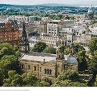 Spektakulärer Blick auf Edinburgh von der Burg auf einem alten Vulkanhügel. Historische Gebäude umgeben von Bäumen.