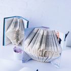 „Booklover“ ist gefaltet, dazu zwei Bücher, ein offenes Notizbuch und ein Stift auf einem weißen Tisch.