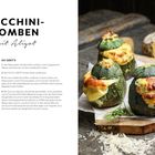 Auf der linken Seite steht "ZUCCHINI-BOMBEN mit Aligot". Rechts gefüllte, gebackene runde Zucchini mit Käse, Holzuntergrund.
