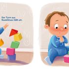 Text: "Der Turm aus Bauklötzen fällt um." und "PLUMPS!"  
Illustration: Kind in blauem Schlafanzug spielt mit Bauklötzen.