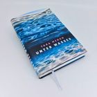 "TARA MENON, UNTER WASSER, ROMAN." Ein Buch mit einem wellenförmigen, blau-weißen Wassermotiv auf dem Umschlag.