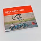 "DOOF HOCH ZWEI. Von einfach dumm bis saugefährlich." Ein Fahrradfahrer springt über vier liegende Personen.