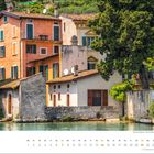 Februar-Kalender mit Datum. Bunte Häuser und Bäume an einem Flussufer in einem idyllischen Dorf.