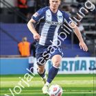 Text: „Sebastian Grønnig“, „CHECKCARS24“, „Hertha BSC“. Fußballspieler in Aktion auf dem Spielfeld. Kalender mit Februar-Tagen.