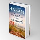 Ein Buchcover mit dem Titel "Im Land des weiten Himmels". Autorin: Elizabeth Haran. Unten: Naturbild mit Bergen.