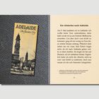 Text: "Adelaide 'The Garden City.'" und "Ein Abstecher nach Adelaide ... Plötzlich hielt neben mir ein Auto."

Beschreibung: Eine Buchseite mit einem alten Foto von Gebäuden.