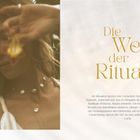 „Die Welt der Rituale." Eine Frau mit geschlossenen Augen und erhobenen Armen, trägt Schmuck, unscharfe Darstellung.
