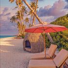 Kalenderblatt: Monat und Jahr sind nicht sichtbar. Zwei Liegestühle auf einem Sandstrand unter Palmen und Sonnenschirm.