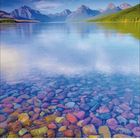 Klarer See mit bunten Steinen, umgeben von Bergen unter blauem Himmel. Am unteren Rand Kalendertage: 1 bis 28.